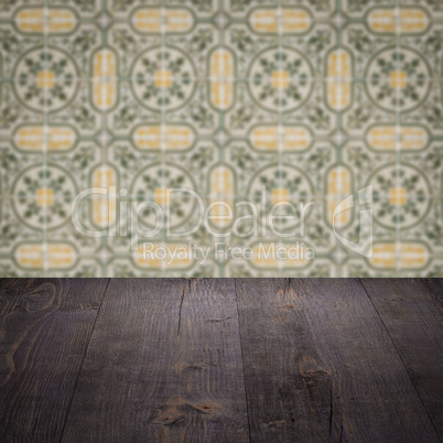 Wood table top and blur vintage ceramic tile pattern wall Wood table top and blur vintage ceramic tile pattern wall