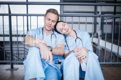 Tired medical team falling asleep on floor