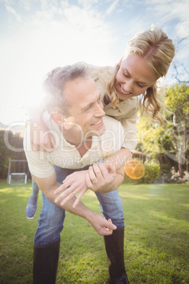 Husband giving piggy back to wife