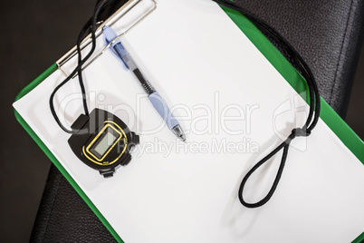 Clipboard and stopwatch on a bench