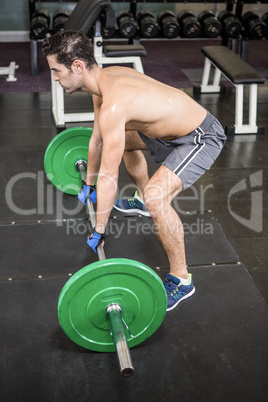 Shirtless man lifting barbell