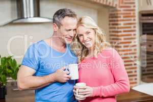 Happy couple holding mugs