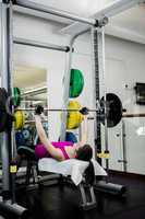 Fit woman lifting the barbell bench press