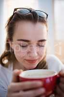 Pretty woman relaxing on couch with coffee