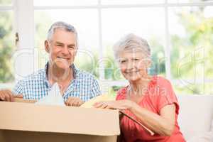 Senior couple opening big box