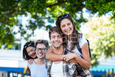 Hip men giving piggy back to their girlfriends