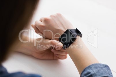 Casual businesswoman using her smart watch