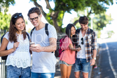 Hip couples checking at smartphone