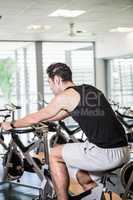 Focused man using exercise bike