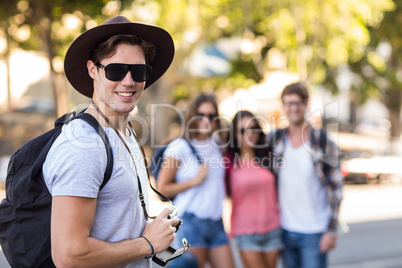 Hip man with digital camera smiling at the camera