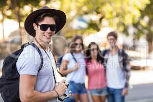 Hip man with digital camera smiling at the camera