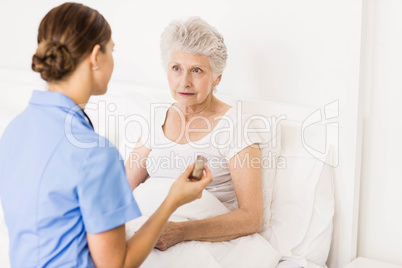 Nurse taking care of suffering senior patient