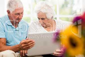 Focused senior couple using laptop