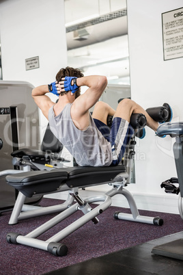 Man doing abdominal crunches on bench