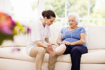 Physiotherapist taking care of sick elderly patient