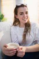 Pretty woman relaxing on couch with coffee