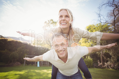 Husband giving piggy back to wife