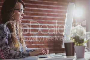 Focused hipster businesswoman watching computer