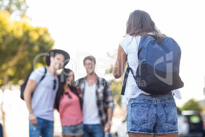 Hip woman taking picture of her friends