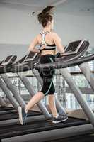 Fit brunette running on treadmill