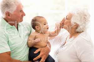 Happy grandparents playing with their grandson