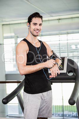 Smiling man on treadmill using smart watch