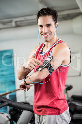 Smiling man on treadmill using smartphone