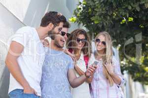 Hip friends looking at smartphone