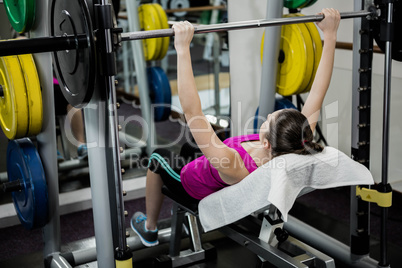 Fit woman lifting the barbell bench press