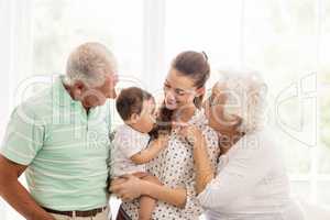 Happy grandparents playing with their grandson