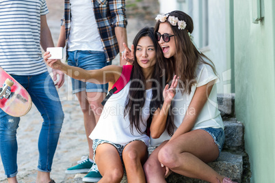 Hip friends taking selfie sitting on steps