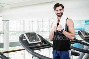 Smiling man standing on treadmill