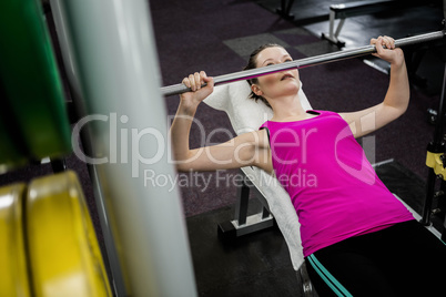 Fit woman lifting the barbell bench press