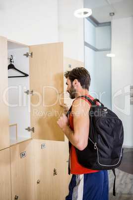 Smiling man opening locker