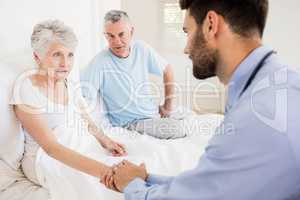 Handsome nurse holding hand of mature woman