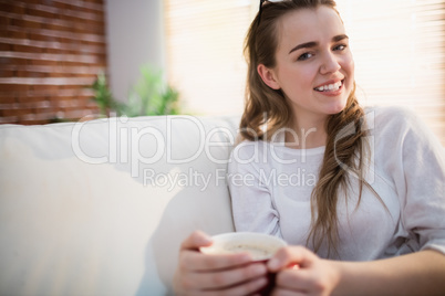 Pretty woman relaxing on couch with coffee