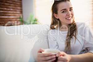 Pretty woman relaxing on couch with coffee