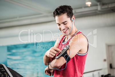 Smiling man on treadmill using smartphone