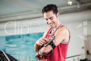 Smiling man on treadmill using smartphone