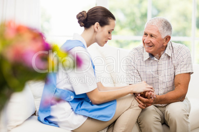 Nurse taking care of sick elderly patient