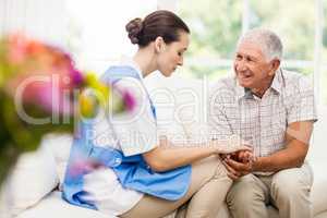 Nurse taking care of sick elderly patient