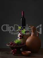 Bottle of red wine, grapes and wooden barrel