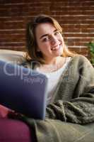 Pretty woman using tablet lying on the couch