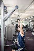 Focused man using weights machine for arms