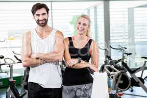 Fit couple smiling at the camera with arms crossed