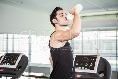 handsome man on treadmill drinking water