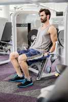 Focused man using weights machine for arms