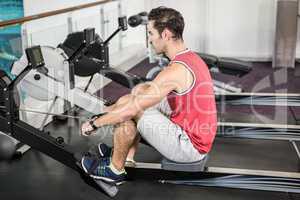 Muscular man on rowing machine