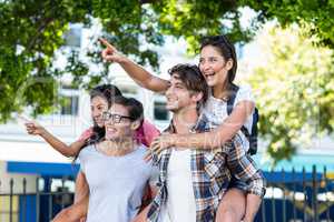 Hip men giving piggy back to their girlfriends