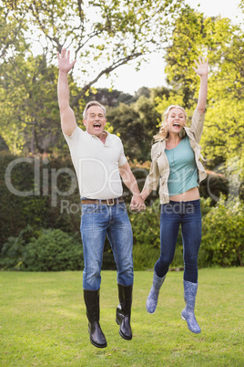 Cute couple jumping with arms in the air